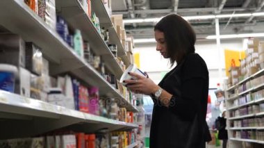 Genç kadın saç maskesi nemlendirmek seçer.