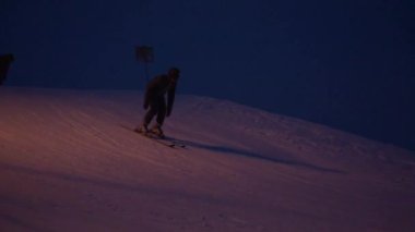 Volzhskii, Rusya Federasyonu - 8 Ocak 2017: Bir adam kısa bir iniş ile akşamları bir Kayak Merkezi, kayaklar üzerinde aşağı gider.