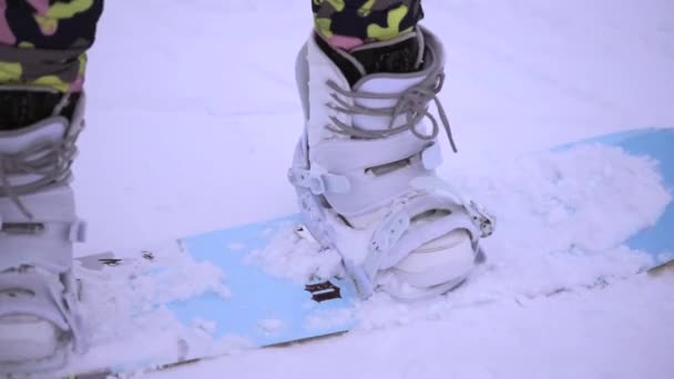 Nära upp skott av kvinnans ben med nya ljusa snowboard utrustning. — Stockvideo