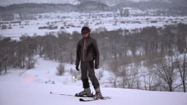 Sporty homem de pé em um terno de esqui e esqui esportivo em uma montanha alta . — Vídeo de Stock