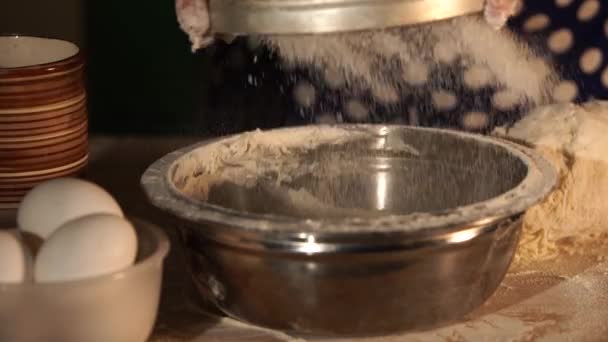 Close-up shot van baker meel zeven door een zeef in de keuken kom. — Stockvideo