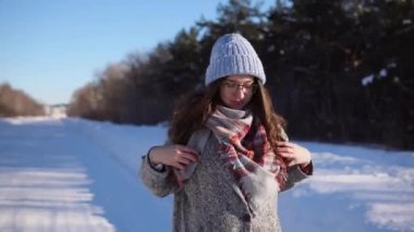 Kış parkta yürüyen genç güzel kadın.