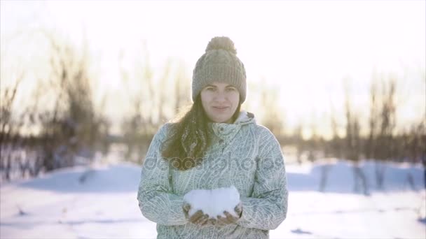 Mujer con nieve en las manos en un bosque de invierno arroja nieve y se regocija . — Vídeos de Stock