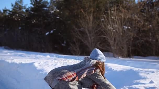 一个年轻的女孩，在晴天下雪的冬天玩乐. — 图库视频影像