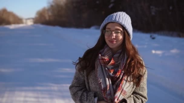 Νεαρή όμορφη γυναίκα το περπάτημα στο δρόμο χειμώνα. — Αρχείο Βίντεο