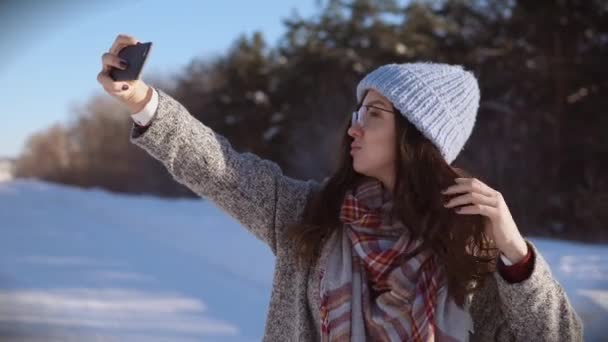 Jonge mooie vrouw poseren voor de camera op een zonnige winterdag. — Stockvideo