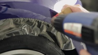 Benzinlikte çalışan erkekler vinil makinede bir karboksilik kullanılarak uygulanan.