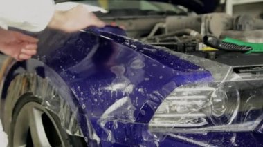 Servis istasyonu işçi yapıştırın vinil pahalı bir araba.