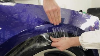 Servis istasyonu ustayı yapıştırın vinil pahalı bir araba.