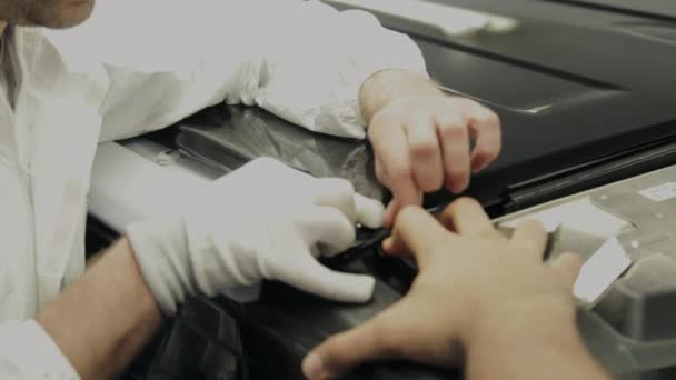 Několik mužů v čerpací stanici umístit vinyl na stroji. — Stock video