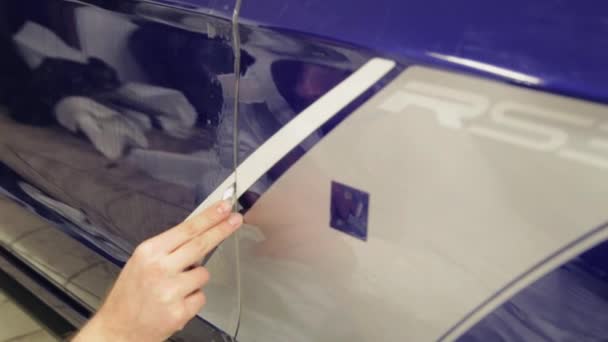 Close-up shot van man met een scherp mes knippen de kloof op de deur van de auto. — Stockvideo