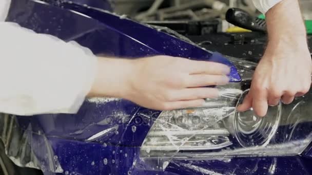 Arbeiter an der Tankstelle nach der Verhängung einer Vinylfolie. — Stockvideo