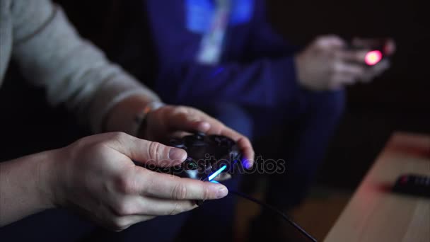 Крупный план двух молодых людей быстро нажимает кнопки на игровых консолях . — стоковое видео