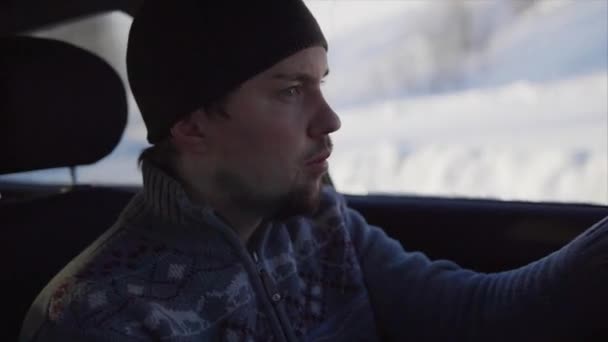 Hombre conduciendo un coche en el camino de invierno . — Vídeos de Stock