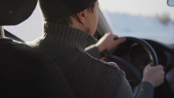 Mann fährt Auto auf winterlicher Straße. — Stockvideo