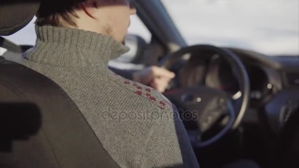 Молодой человек водит машину по зимней дороге. Вид сзади . — стоковое видео