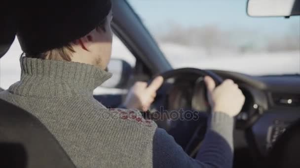 Young man driving car on the winter road. — Stock Video