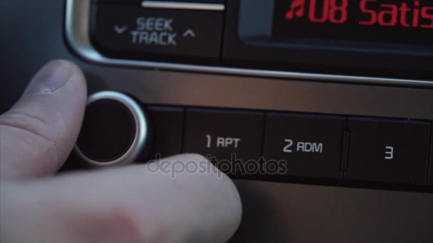 Mans hand med en runda knappen gör att volymen av musiken i bilen tystare. — Stockvideo