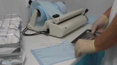 Dişçi aletleri sterilizasyon için hazırlar.