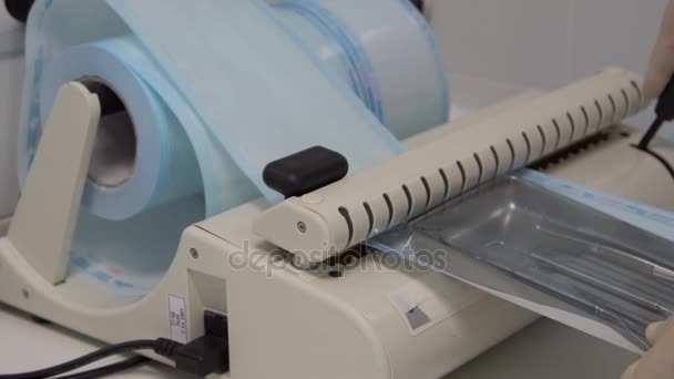 Hospital worker using special equipment packs kraft bag with dental tools. — Stock Video