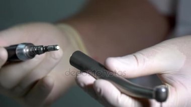 Doktorlar atış kadar elinde elektrikli diş matkap uygun eldiven kapatmak.