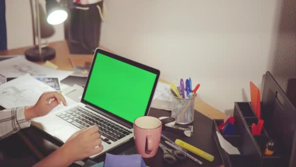 Designer in his office enters the information on laptop chroma key on the screen — Stock Video