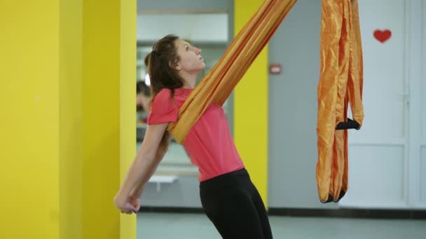 El principiante del yoga aéreo hace asana para estirar pecho y espalda usando la hamaca — Vídeo de stock