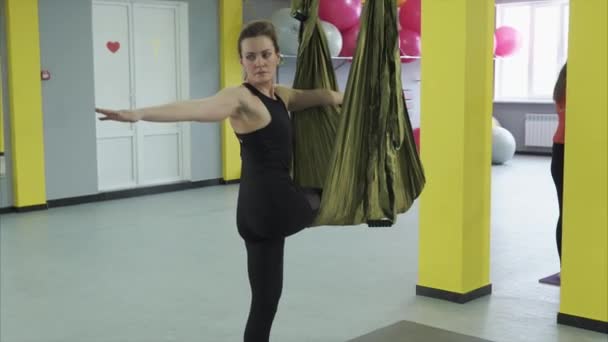 Las mujeres hacen asana poses, la postura inversa de pie con una pierna alargada — Vídeos de Stock