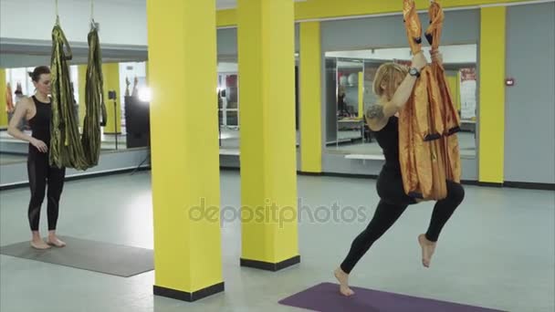 Kız asanas sinek yoga yapar, o yardımcı olur elastikiyeti artırır — Stok video