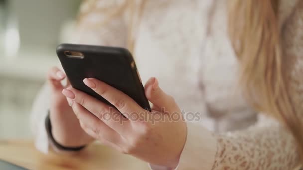 Nära upp skott av en ung kvinna händer, som innehar en smartphone. — Stockvideo