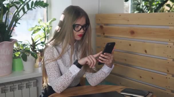 Stilvolle Geschäftsfrau überprüft eingehende Briefe auf Handy in Caf — Stockvideo