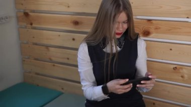 Genç iş kadını cep telefonu, elinde yeni bir akıllı saat görünüyor