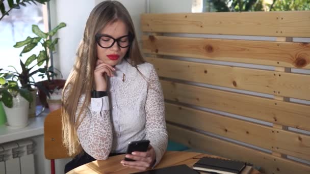 Όμορφη γυναίκα μοιάζει σκεπτικά στην οθόνη του smartphone, ελέγχοντας το ηλεκτρονικό ταχυδρομείο — Αρχείο Βίντεο