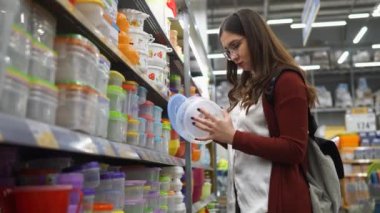 Genç kadın plastik beslenme çantası seçer, ürünler uzun süre taze kalır.