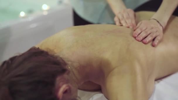 Крупный план рук терапевта, который массирует девочек обратно с помощью масла — стоковое видео