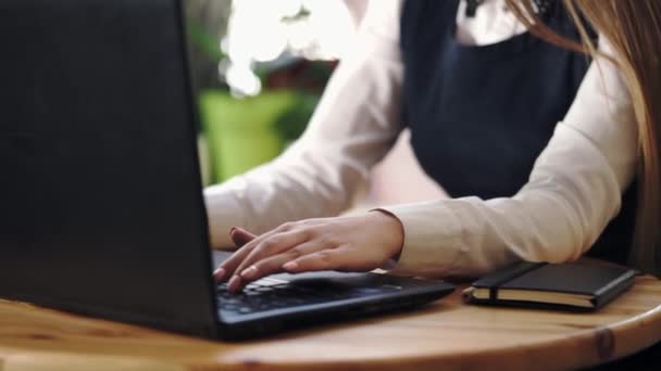 Nära upp skott av en ung kvinna att skriva text på en bärbar dator — Stockvideo