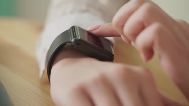 Makroaufnahme der Finger einer jungen Frau, die die Nachrichten auf einer Smartwatch checkt — Stockvideo