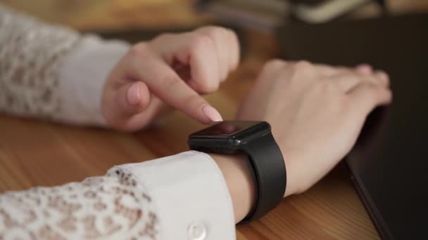 Κοντινό πλάνο του νεαρή γυναικεία χέρια που χρησιμοποιεί μια έξυπνη ρολόγια για business εργασία — Αρχείο Βίντεο