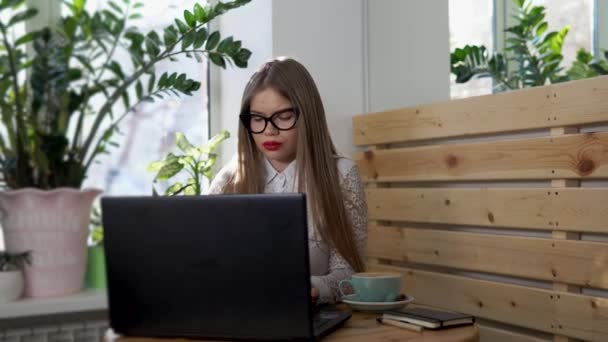 Молода серйозна бізнес-леді в окулярах друкує електронну пошту на ноутбуці . — стокове відео