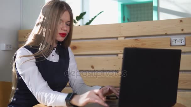 若い女性のスマートな腕時計彼女の手にノート パソコンの社会的なネットワークのニュースを閲覧 — ストック動画