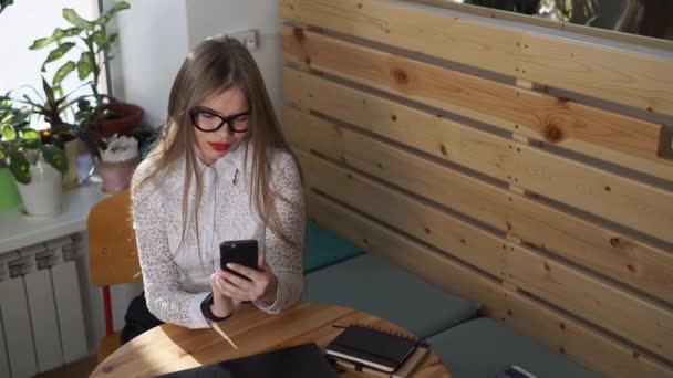 Mujer de negocios está viendo noticias en su teléfono inteligente durante la pausa para el almuerzo — Vídeos de Stock