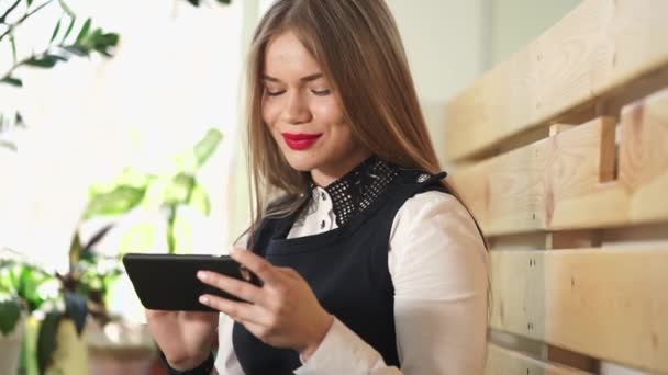 Mujer bonita joven mira fotos en las redes sociales en su teléfono móvil — Vídeos de Stock