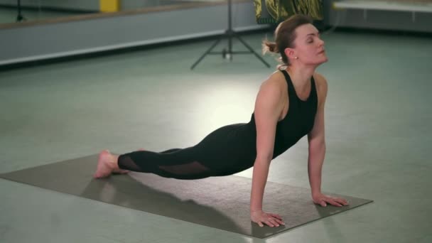 Filmagem em câmera lenta da menina que faz uma transição suave de um asana para outro — Vídeo de Stock