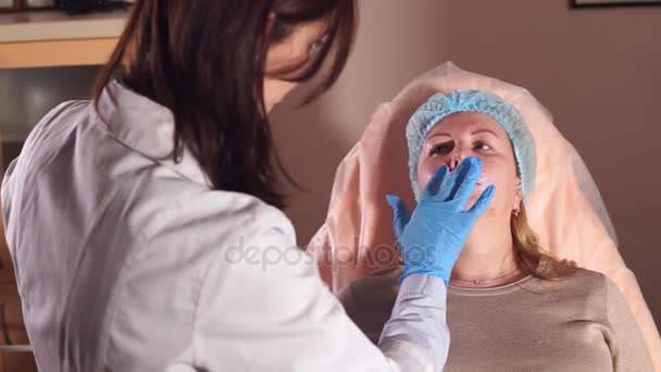 O doutor espera enquanto a anestesia em umas pregas nasolabiais atuará para fazer uma nyxis — Vídeo de Stock