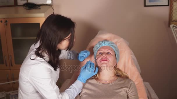 The doctor make injects with botox into the chin zone, then disinfects that — Stock Video