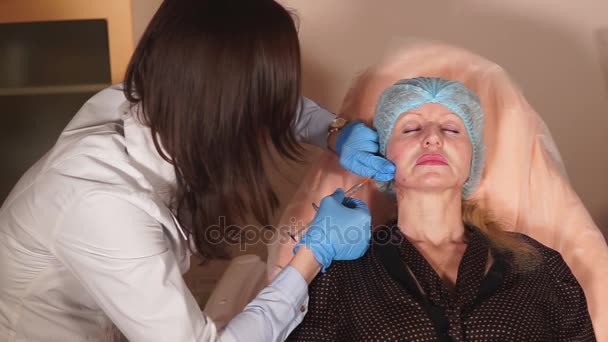 Shot del proceso de introducción de rellenos en el perímetro de la cara de las mujeres — Vídeos de Stock