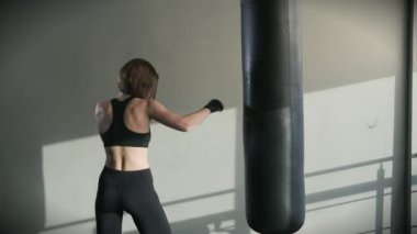 Genç kadın eğitim kum torbası fitness salonunda