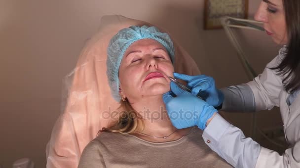 医者が患者の鼻唇溝のしわにボトックスの注入を刺し傷 — ストック動画