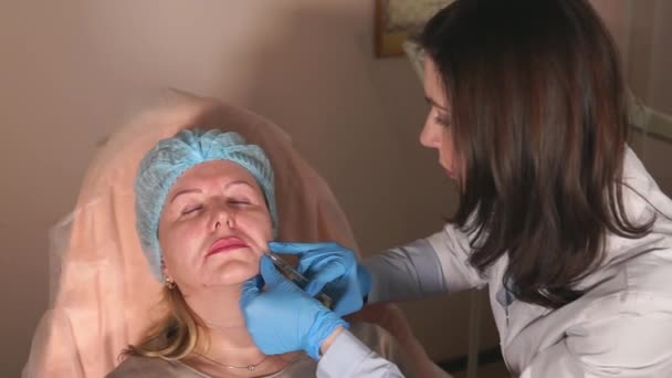 The doctor punctures the injection of Botox into nasolabial wrinkles for patient — Stock Video