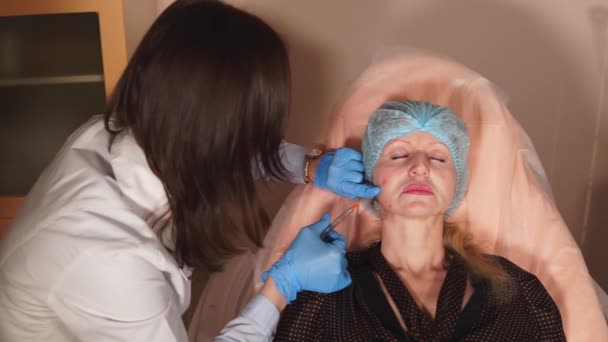 Le médecin du cosmétologue introduit l'implant injectable avec la canule . — Video